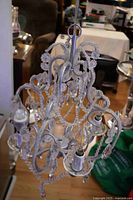 Full view of chandelier showing four arms, beads, drops, and bulbs