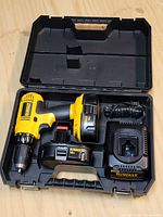 Open case showing drill, two batteries and charger