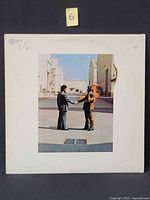 Front cover showing two men shaking hands, one on fire