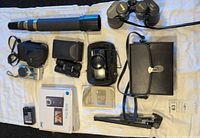 Overview of all optical and camera items laid out on white cloth