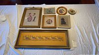 All seven framed needlework pieces displayed together