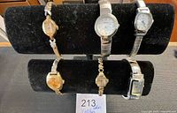 Six watches displayed on two-tier stand