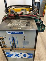 Front view of Mastercraft welder with cables and cart