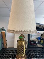 Full view of lamp with fabric shade atop brass lantern base