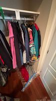 Closet rod view showing multiple jackets, hoodies and cardigans on hangers