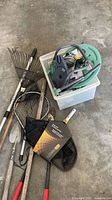 Overall lot showing assorted tools, nets, hose reel parts in tote