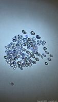 Group of small round faceted tanzanite stones on white surface