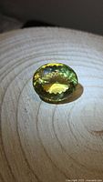 Oval faceted lemon citrine on wood surface