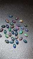 Group of Ethiopian black opal cabochons on textured background