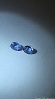Pair of oval blue sapphires on neutral background