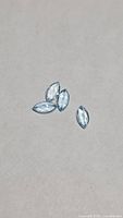 Four marquise-cut sky blue topaz gemstones on neutral background