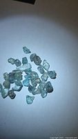 Group of blue zircon rough crystals scattered on white background