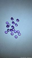 Group of small round purple amethysts on light surface