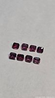 Set of eight square/octagon-cut pink sapphires on neutral background