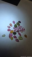 Group of multicoloured leaf-cut tourmaline stones on white background