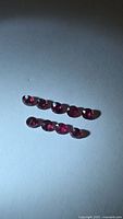 Nine round rubies arranged in two rows