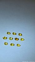 Ten yellow sapphires arranged on a neutral background
