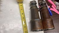 binoculars next to tape showing about 6 in. length