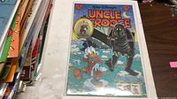 Front cover of Walt Disney’s Uncle Scrooge #295 in bag and board beside other comics