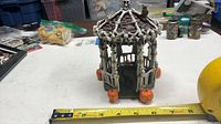Full view of skeleton gazebo figurine next to measuring tape