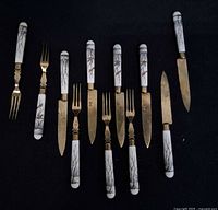 Group of matching fruit knives and forks showing full set