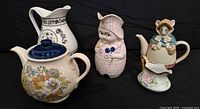 Four ceramic items: floral teapot with lid, floral pitcher, woman-shaped teapot, mouse-shaped teapot