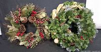 Two decorated artificial wreaths side by side