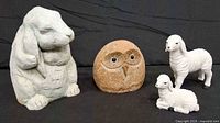 Front view of rabbit, stone owl, standing sheep, lying lamb