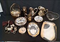 Overall lot showing all silver plate items on black backdrop