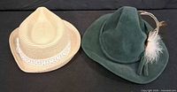 Straw fedora and green Tyrolean hat side by side