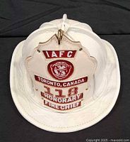 Front view of white leather firefighter helmet showing eagle shield holder and brim detailing