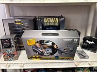 Overall view of seven boxed Batman items on shelf