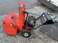Left side view of Ariens 8526 snow blower showing auger housing, chute, engine and wheels
