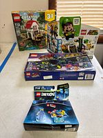 Four sealed Lego set boxes displayed on table