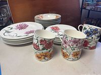 Stack of dinner and salad plates with teacups