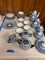 Full layout of cobalt net tea service showing plates, cups, teapot, sugar bowl, creamer, lidded pots