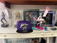 Shelf view showing all seven items including figures and hat