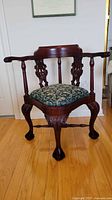 Full front view of carved mahogany corner armchair