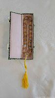 Prayer beads in open box showing interior lining and tassel