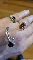 All three jewellery pieces on hand showing relative sizes and amber colors
