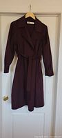 Full front view of burgundy Zara coat hanging on door