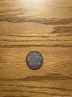 Reverse view showing denomination 25 CENTS 1872 with maple leaf wreath and crown