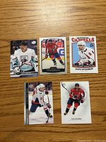 Front view of five Alex Ovechkin hockey cards laid out on wood surface