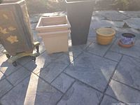 Five visible planters and saucer on stone patio