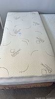 Top view of Twin XL mattress topper on bed showing quilted organic cotton cover