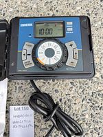 Front view of controller showing LCD display, dial, buttons, attached power cord