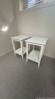 Pair of white square end tables angled view