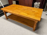 Full view of rectangular coffee table showing top surface, shelf, legs
