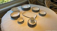 Full set displayed on table showing all stacks of plates, bowls, mug, platter, serving bowl