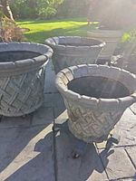 Four planters visible; front three appear matching basketweave planters on caddies